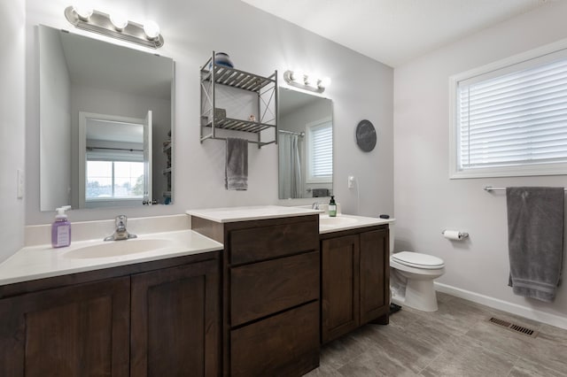 bathroom featuring vanity, toilet, and walk in shower