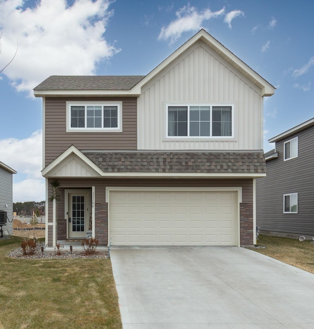 view of front of home with concrete driveway, roof with shingles, an attached garage, a front lawn, and board and batten siding