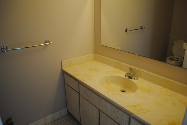 bathroom featuring tile patterned flooring, vanity, and toilet