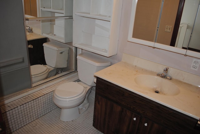 bathroom with toilet, a shower, vanity, and tile patterned flooring