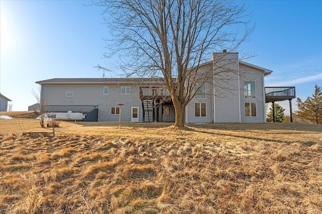 back of house featuring a chimney, stairs, and a deck