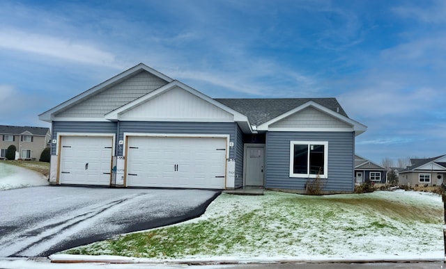 view of front of home featuring a garage, driveway, and a shingled roof