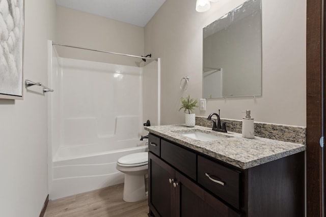 bathroom with  shower combination, vanity, toilet, and wood finished floors