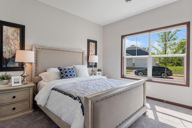 bedroom with baseboards and light colored carpet