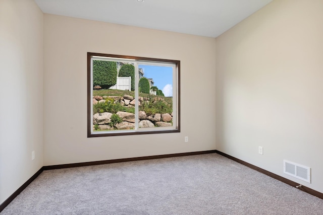 spare room featuring carpet flooring, visible vents, and baseboards