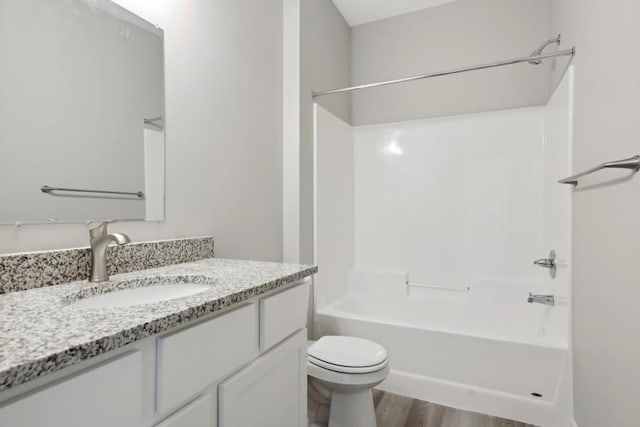 full bath featuring bathtub / shower combination, vanity, toilet, and wood finished floors