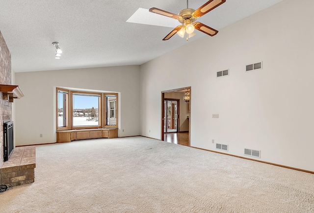 unfurnished living room with carpet floors, ceiling fan, a brick fireplace, a textured ceiling, and high vaulted ceiling