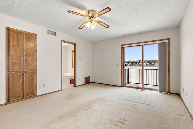 carpeted empty room with a textured ceiling and ceiling fan