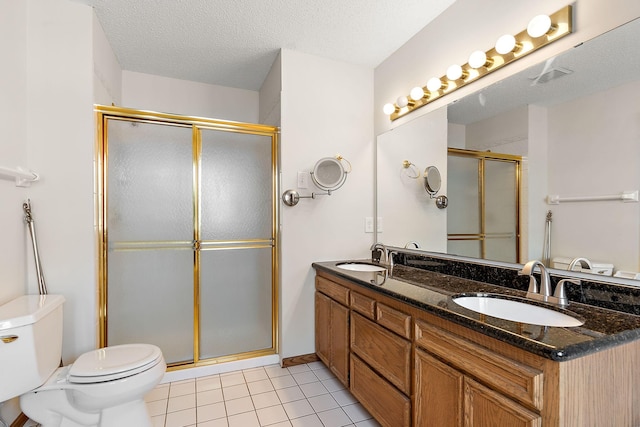 bathroom with a shower with shower door, a textured ceiling, tile patterned floors, and vanity