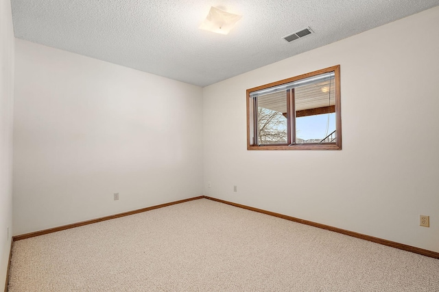 unfurnished room with a textured ceiling and carpet flooring