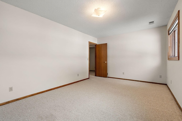 carpeted spare room featuring a textured ceiling