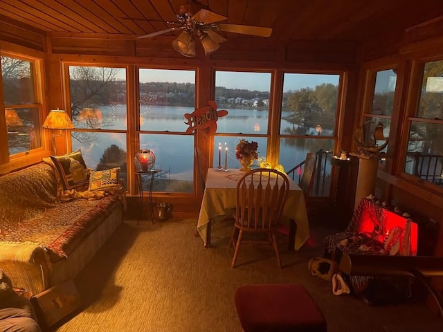 sunroom / solarium featuring a water view, ceiling fan, and wooden ceiling