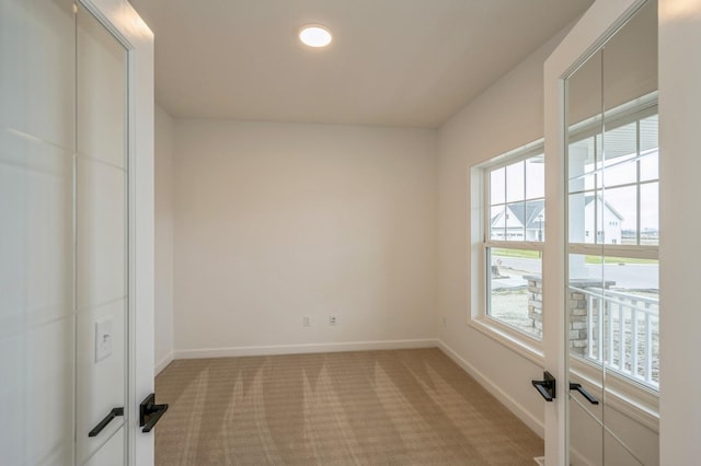 unfurnished room featuring light carpet