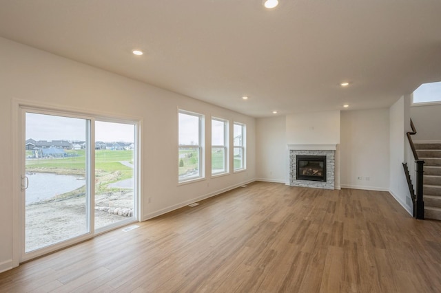 unfurnished living room with a fireplace and light hardwood / wood-style floors