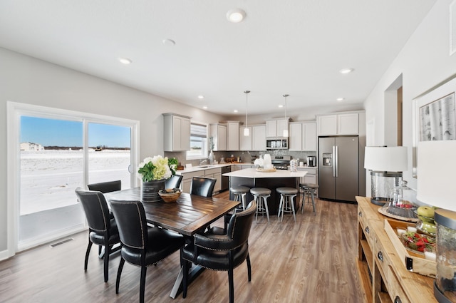 dining space featuring light wood-type flooring and sink