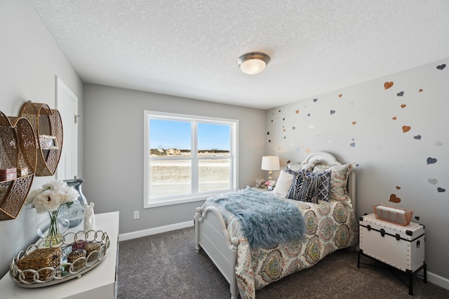 bedroom with dark colored carpet and a textured ceiling