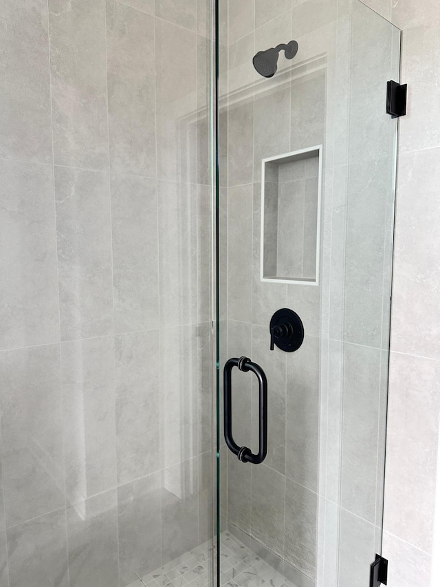 bathroom with a shower with door