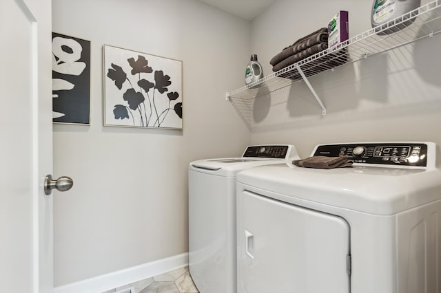 laundry area with separate washer and dryer and light tile patterned floors