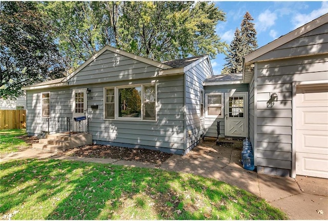 ranch-style house featuring an attached garage, fence, and a front yard