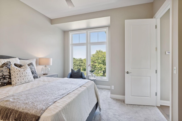 bedroom featuring multiple windows, light colored carpet, and ceiling fan