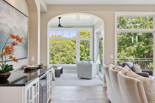 doorway to outside with ornamental molding, ceiling fan, and light wood-type flooring