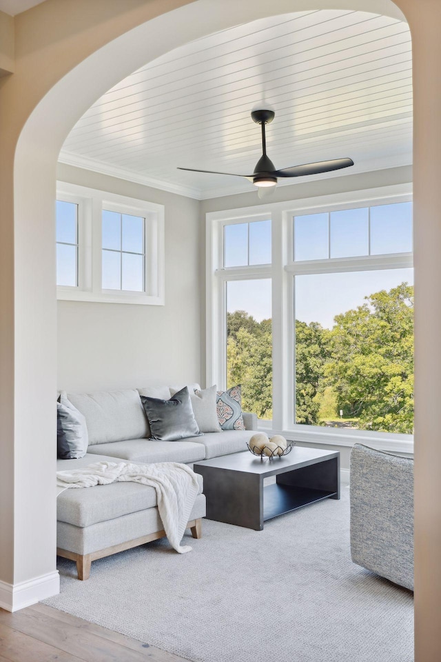 living room with crown molding, ceiling fan, and wood-type flooring