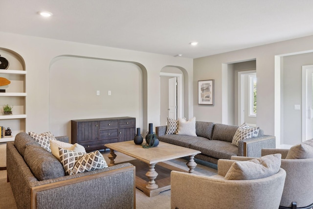 carpeted living room featuring built in shelves