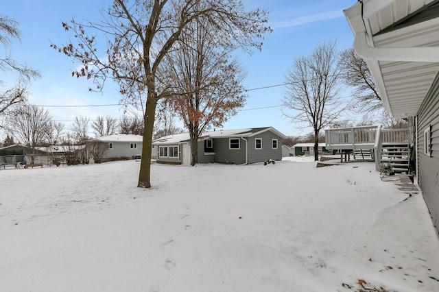 yard covered in snow featuring a wooden deck