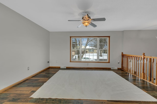 empty room featuring ceiling fan and dark wood-type flooring