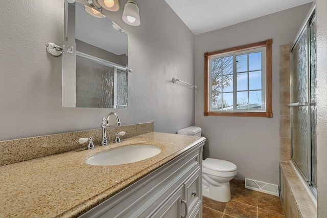 bathroom with vanity, toilet, and an enclosed shower