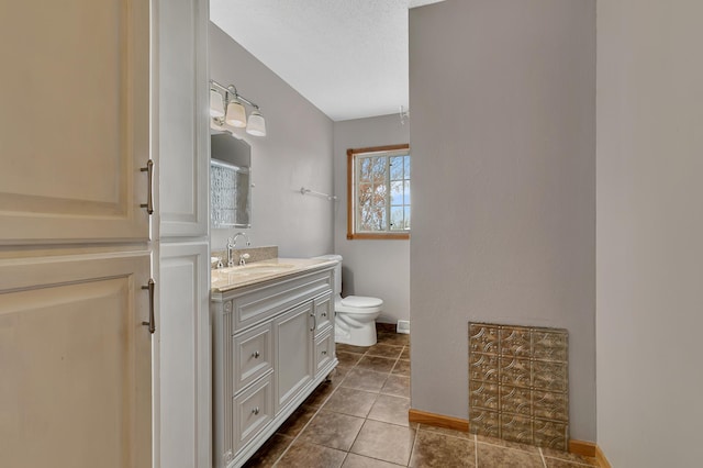 bathroom featuring tile patterned floors, vanity, a textured ceiling, and toilet