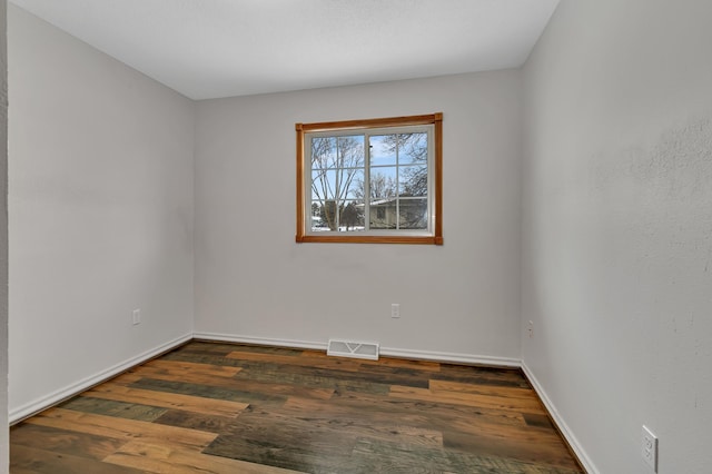 empty room with dark hardwood / wood-style flooring