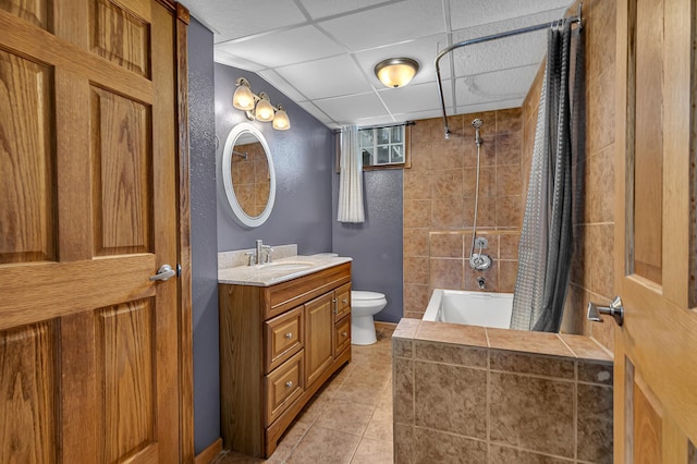 full bathroom featuring a paneled ceiling, vanity, tile patterned floors, toilet, and shower / bath combo with shower curtain