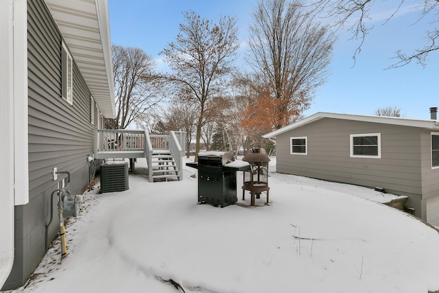 snowy yard with cooling unit and a deck