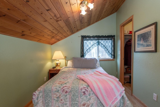 bedroom with a walk in closet, wooden ceiling, hardwood / wood-style floors, a closet, and lofted ceiling