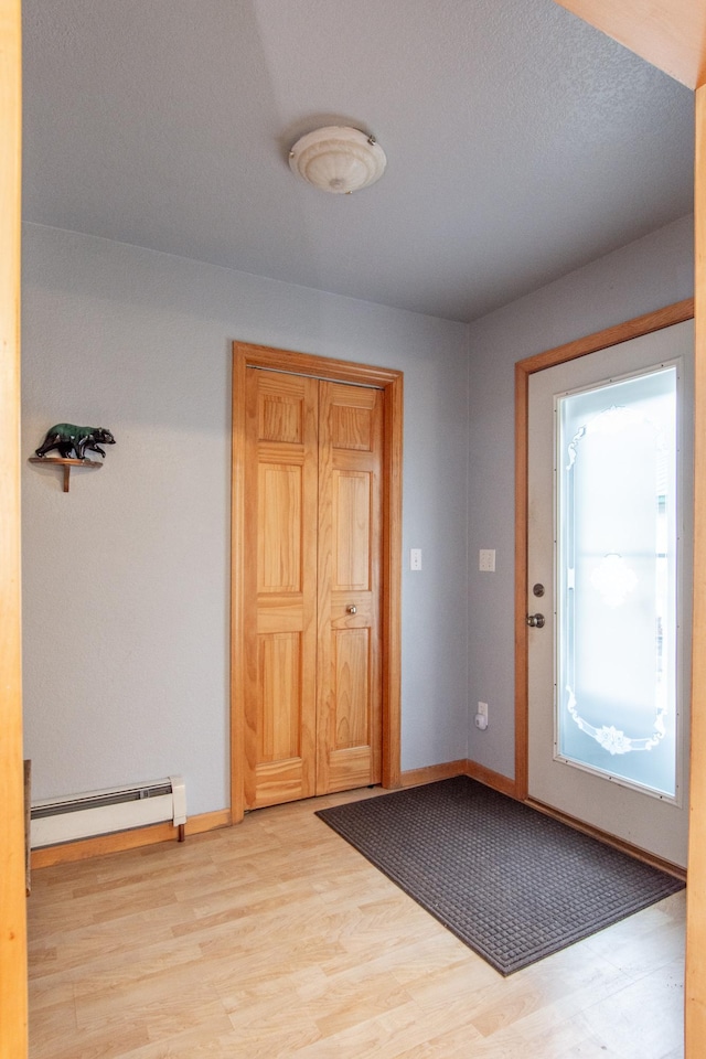 interior space featuring baseboard heating and light wood-type flooring