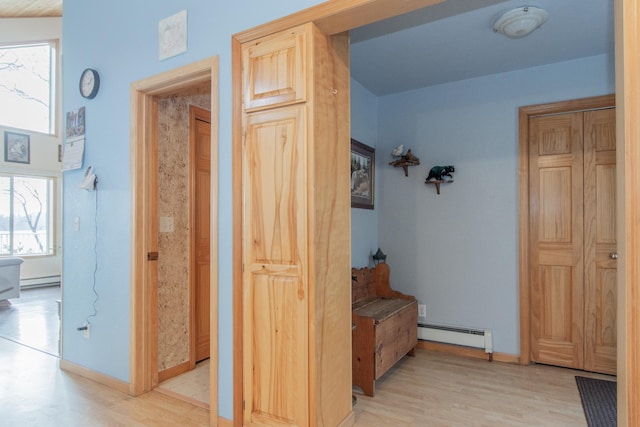 corridor featuring light wood-type flooring and a baseboard radiator