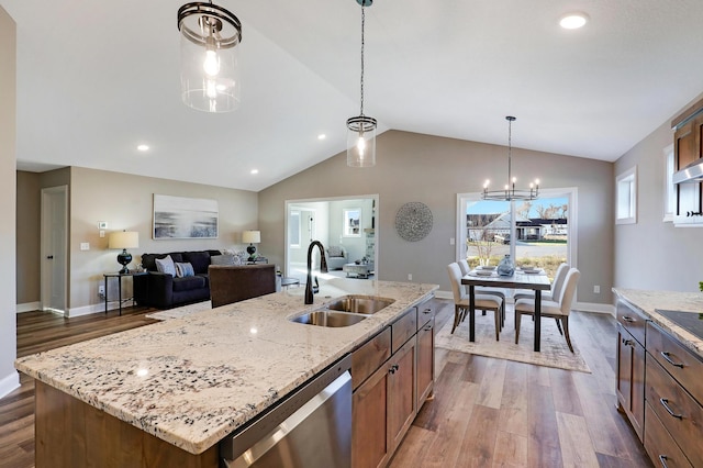 kitchen with sink, hanging light fixtures, stainless steel dishwasher, dark hardwood / wood-style floors, and an island with sink