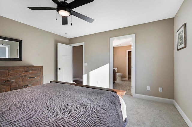 carpeted bedroom with ceiling fan and ensuite bath