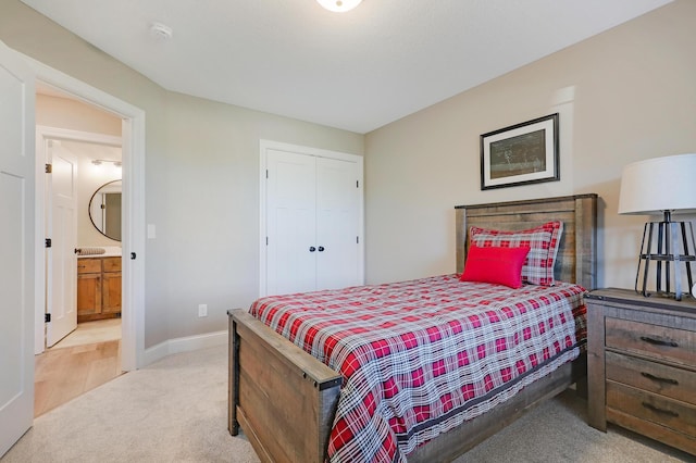 carpeted bedroom featuring ensuite bath and a closet