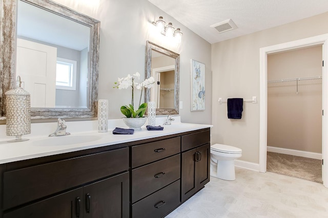 bathroom with vanity, a textured ceiling, and toilet