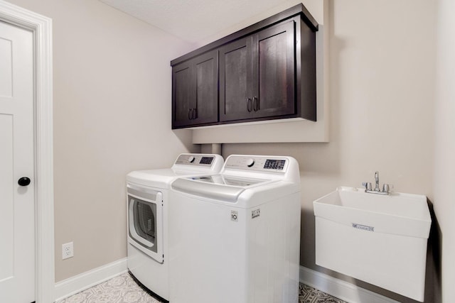 laundry room with cabinets, washing machine and dryer, sink, and a textured ceiling