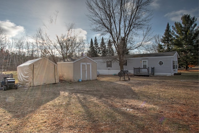 back of house with a deck and a storage unit