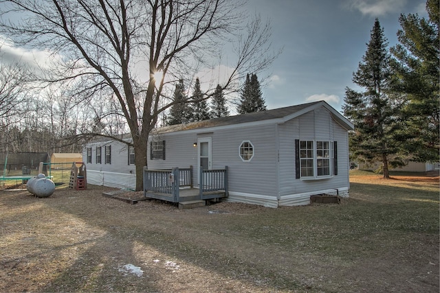 manufactured / mobile home with a deck and a front yard