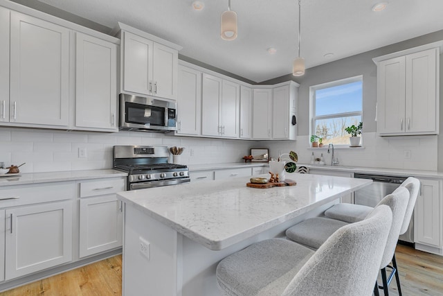 kitchen featuring white cabinetry, pendant lighting, a center island, and stainless steel appliances