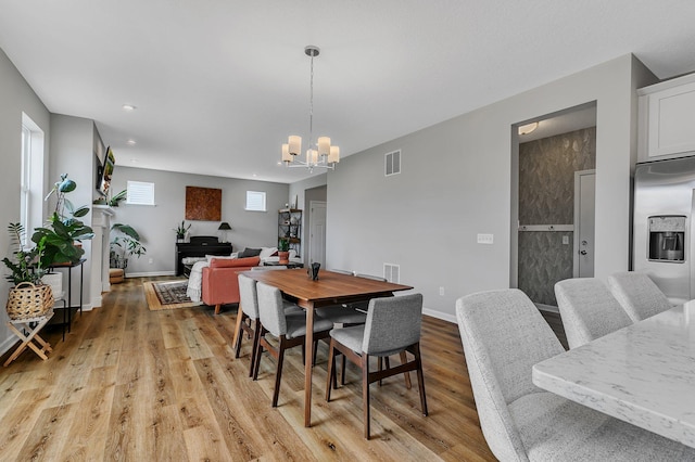 dining area with a chandelier and light hardwood / wood-style floors