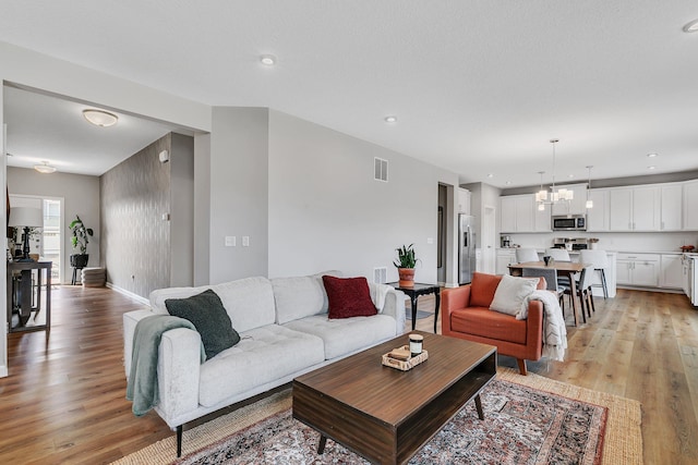 living room featuring light hardwood / wood-style flooring and a notable chandelier