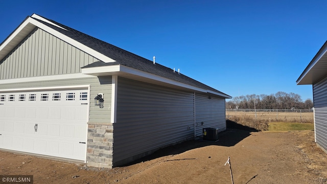 view of side of property with central AC and a garage