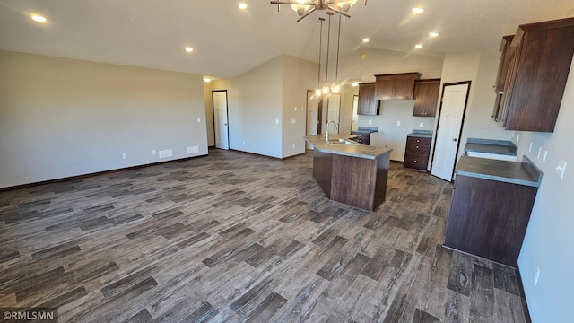 kitchen featuring pendant lighting, a kitchen island with sink, sink, dark hardwood / wood-style floors, and a chandelier