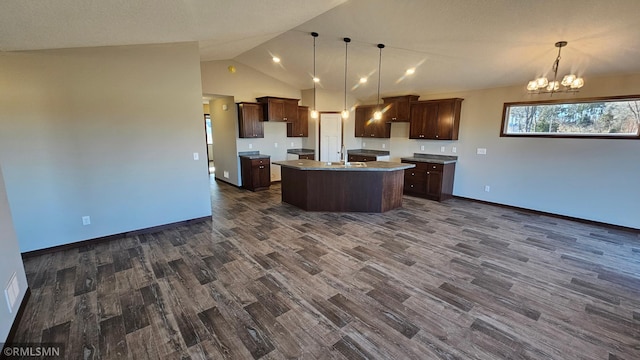 kitchen featuring sink, hanging light fixtures, an inviting chandelier, an island with sink, and lofted ceiling